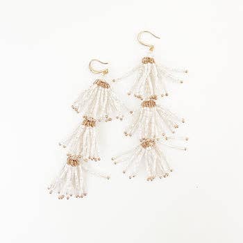 A pair of Aster Fleur earrings featuring glass beads in white and gold colors, displayed on a white background.
