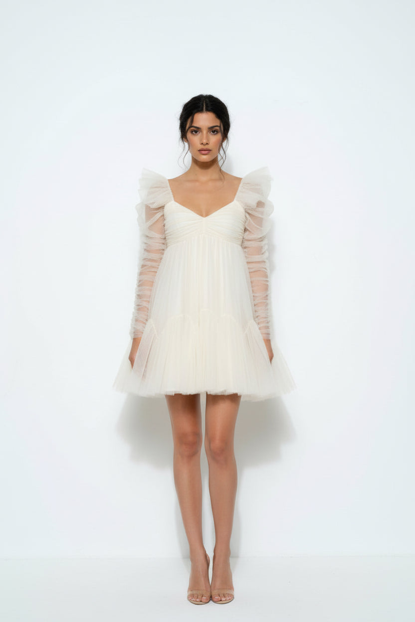 Dani effortless bridal dress Woman wearing a white dress with sheer sleeves on a white background