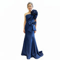 Eve mother of the bride dress Woman wearing a blue evening gown with a large bow and floral detail on a white background