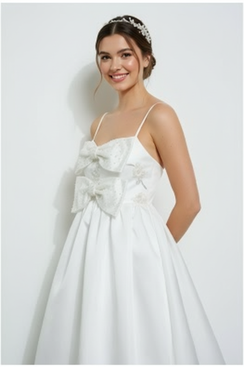 Lynda timeless bridal dress Woman wearing a white dress with a large bow on a white background